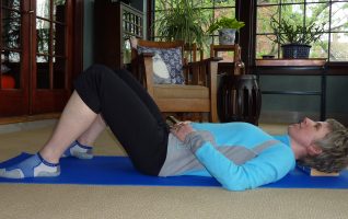 Demonstration of the Constructive Rest position with legs bent and feet flat on the floor