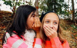 two girls telling secrets