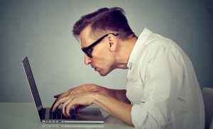 man hunched over laptop