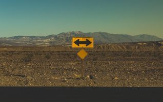 a road sign with arrows pointing left and right