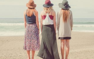 three women standing on a beach