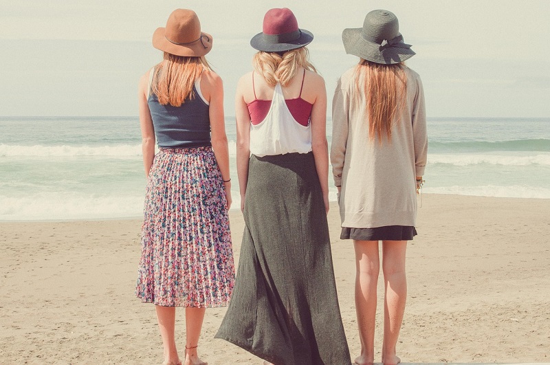 three women standing on a beach