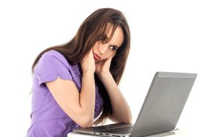 woman hunched over laptop