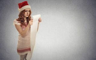 girl with santa hat holding long list