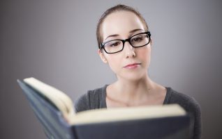 woman holding a book at a good height for reading