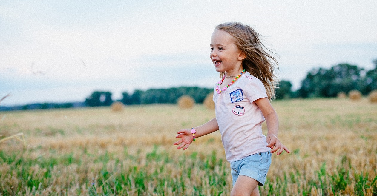 little girl joyfully running in field