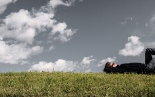 man lying on his back in the grass
