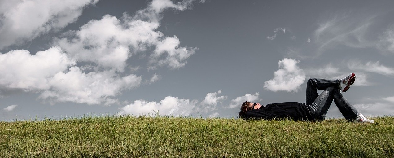 man lying on his back in the grass