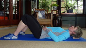 Demonstration of the Constructive Rest position with legs bent and feet flat on the floor
